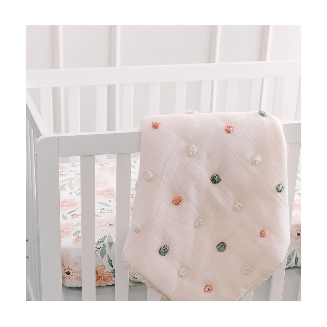 Wrap your little one in the Crane Baby Parker Pom Pom Blanket, a stylish baby girl blanket ideal for naps and tummy time.