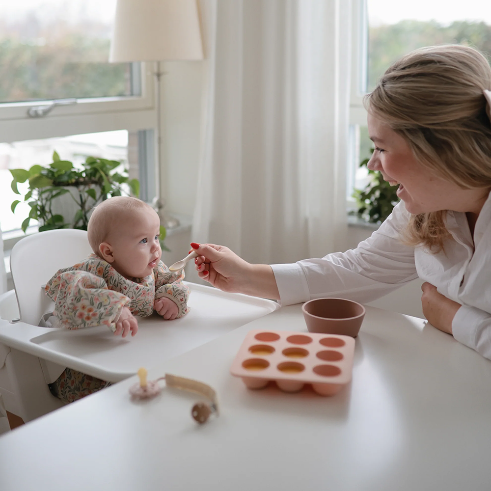 mom feeding baby from mushi freeze tray pink