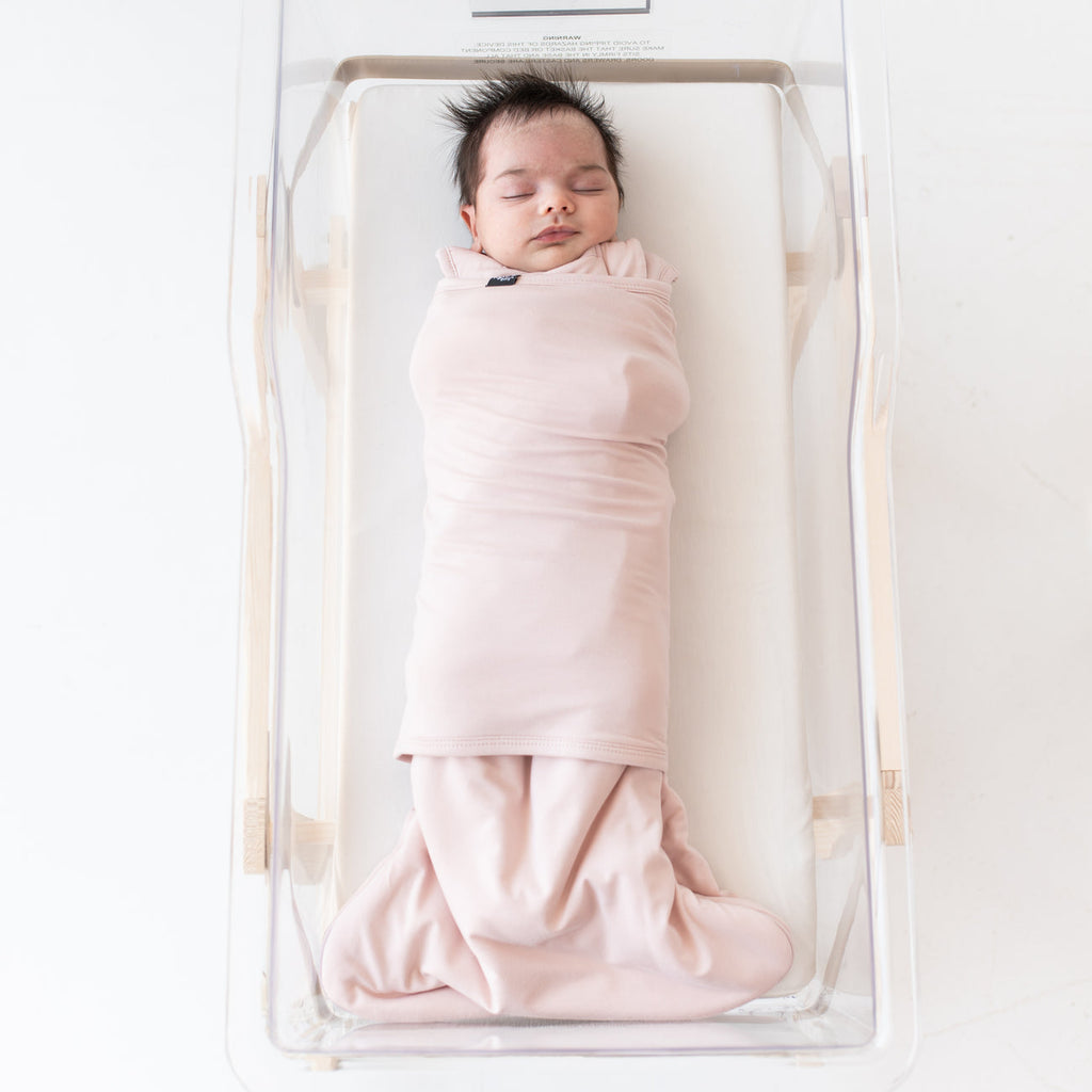 newborn in kyte baby blush sleep bag swaddler