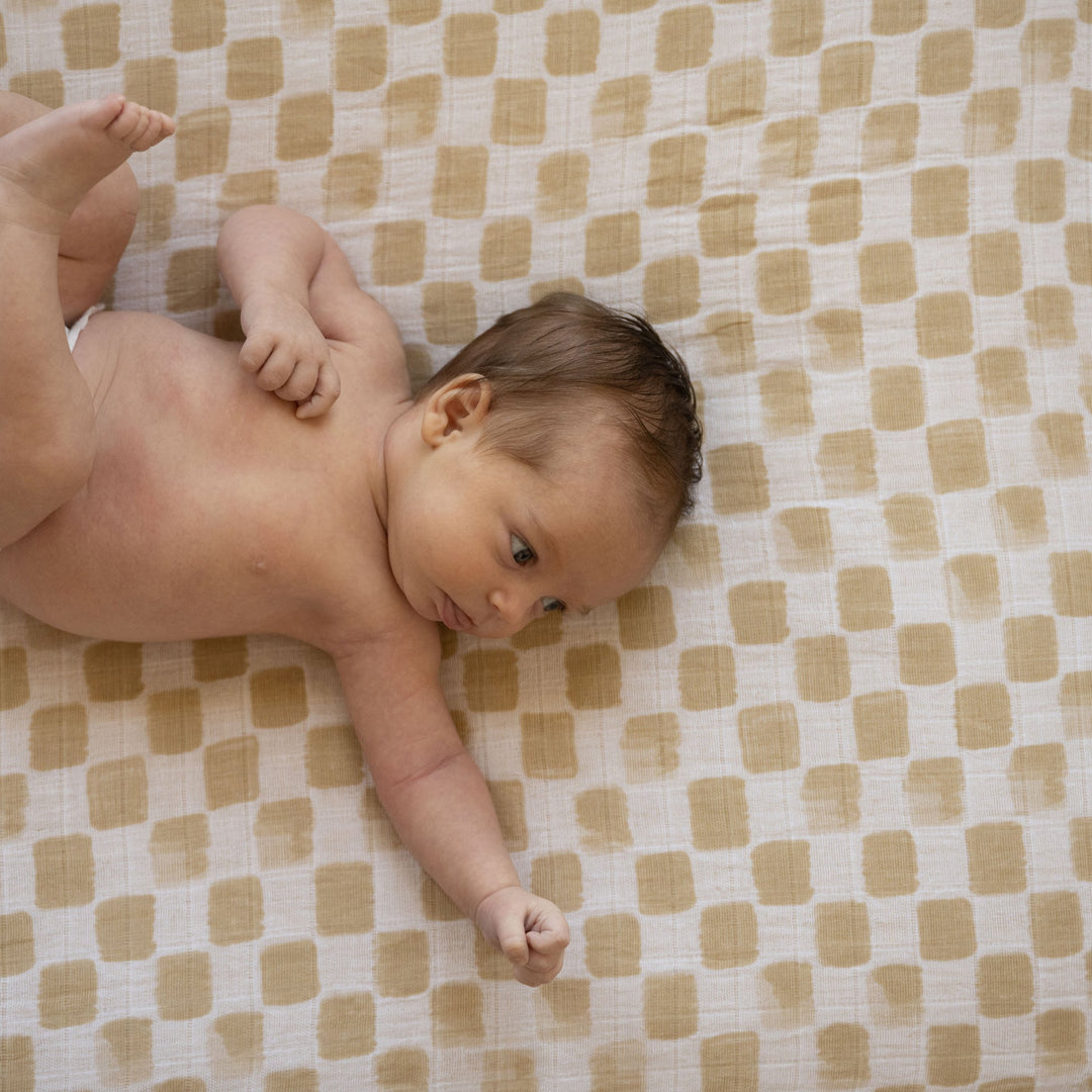 Little Unicorn Adobe Checker Cotton Muslin Crib Sheet styled on crib, one of the best crib sheets for newborns