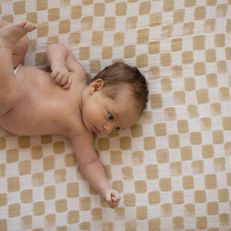 Little Unicorn Adobe Checker Cotton Muslin Crib Sheet styled on crib, one of the best crib sheets for newborns