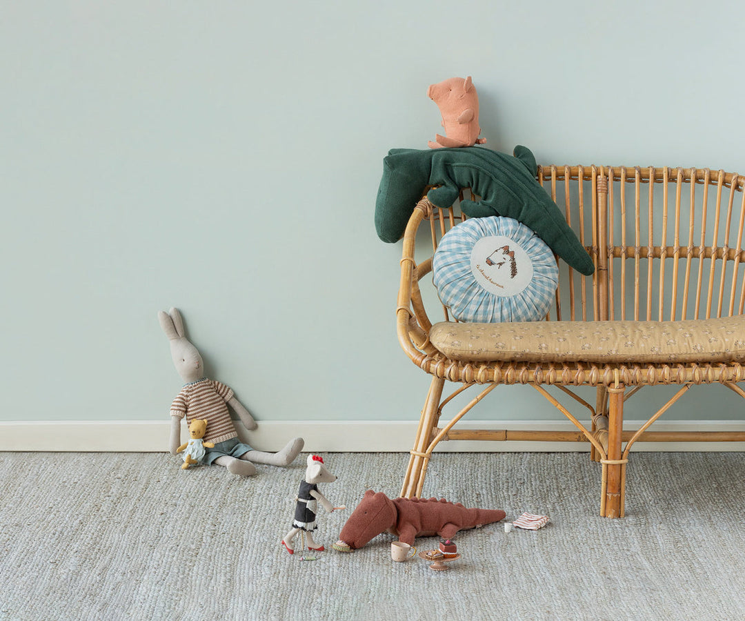 Maileg Safari Friends Crocodile Small Vintage Rose lifestyle scene with Maileg doll on rattan bench