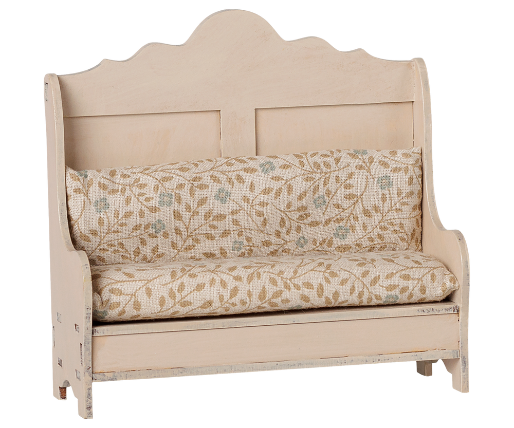 Angled view of the Maileg Kitchen Bench in light sand, arched-back mouse furniture with floral seat