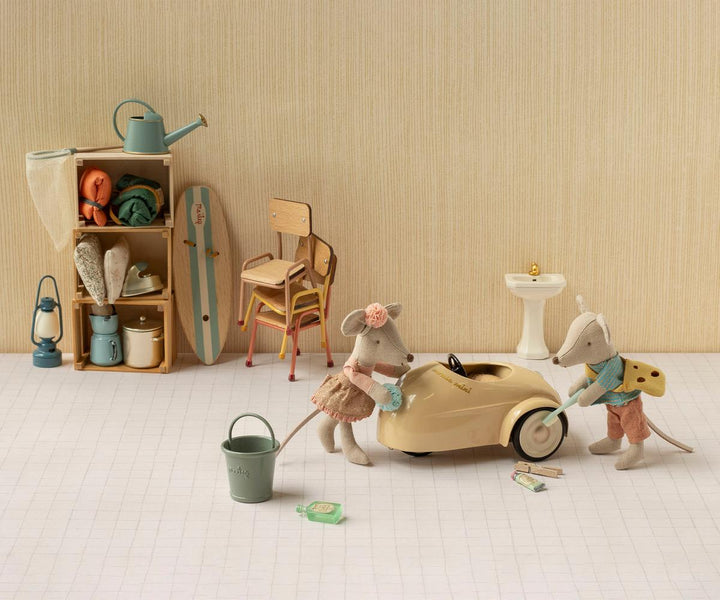 Maileg mouse family playing among shelf toys and a rocking horse, dollhouse lifestyle scene