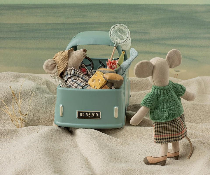 Maileg mouse family riding together in their car, imaginative dollhouse storytelling scene