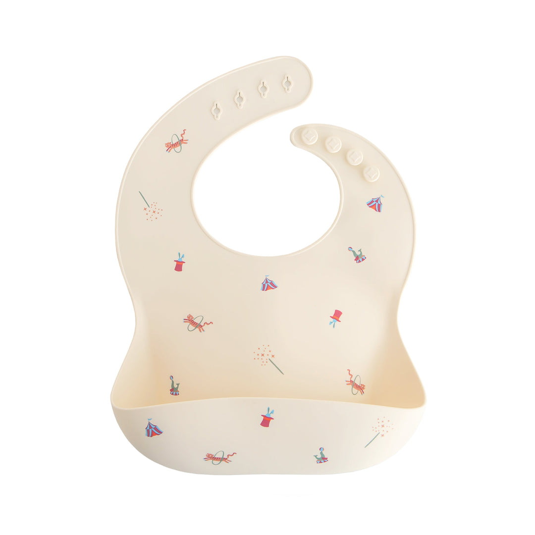 Mushie Silicone Bib in Circus print with adjustable strap for mess-free baby feeding