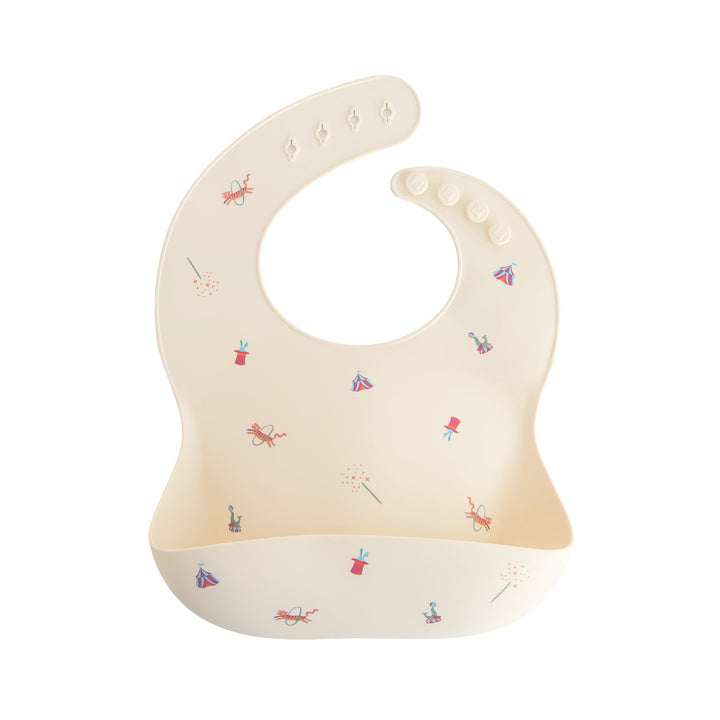Mushie Silicone Bib in Circus print with adjustable strap for mess-free baby feeding