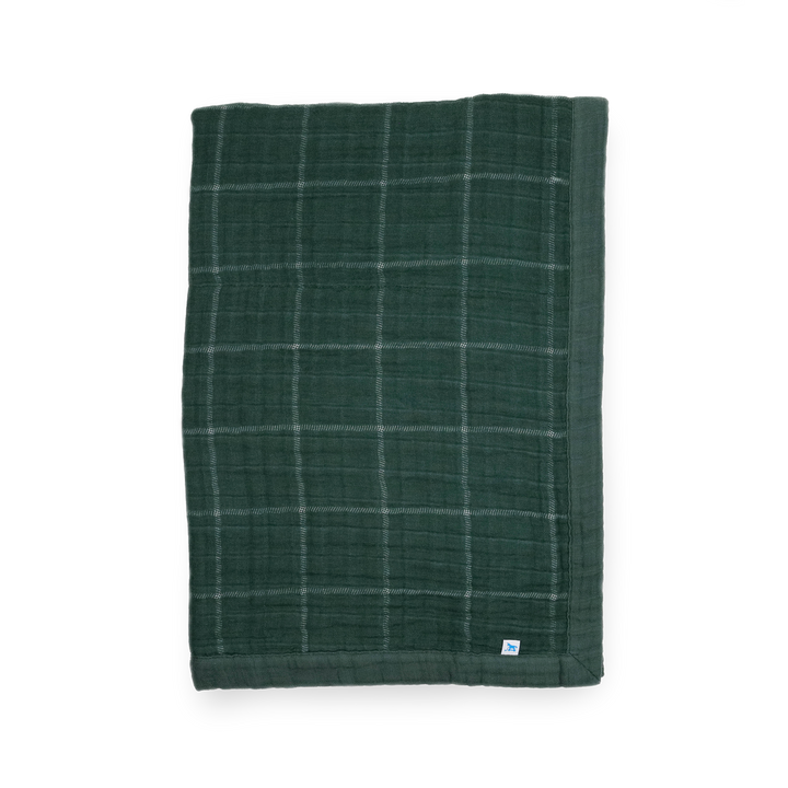 Little Unicorn Cotton Muslin Baby Quilt - Evergreen Plaid displayed in a classic green plaid, a cozy baby blanket for nursery or stroller.