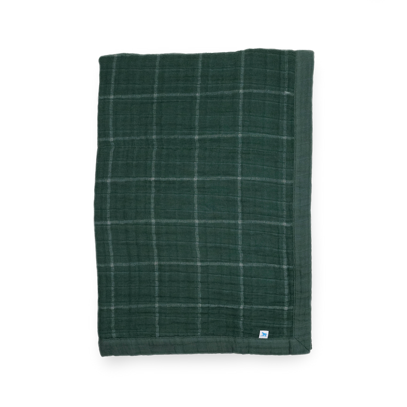 Little Unicorn Cotton Muslin Baby Quilt - Evergreen Plaid displayed in a classic green plaid, a cozy baby blanket for nursery or stroller.