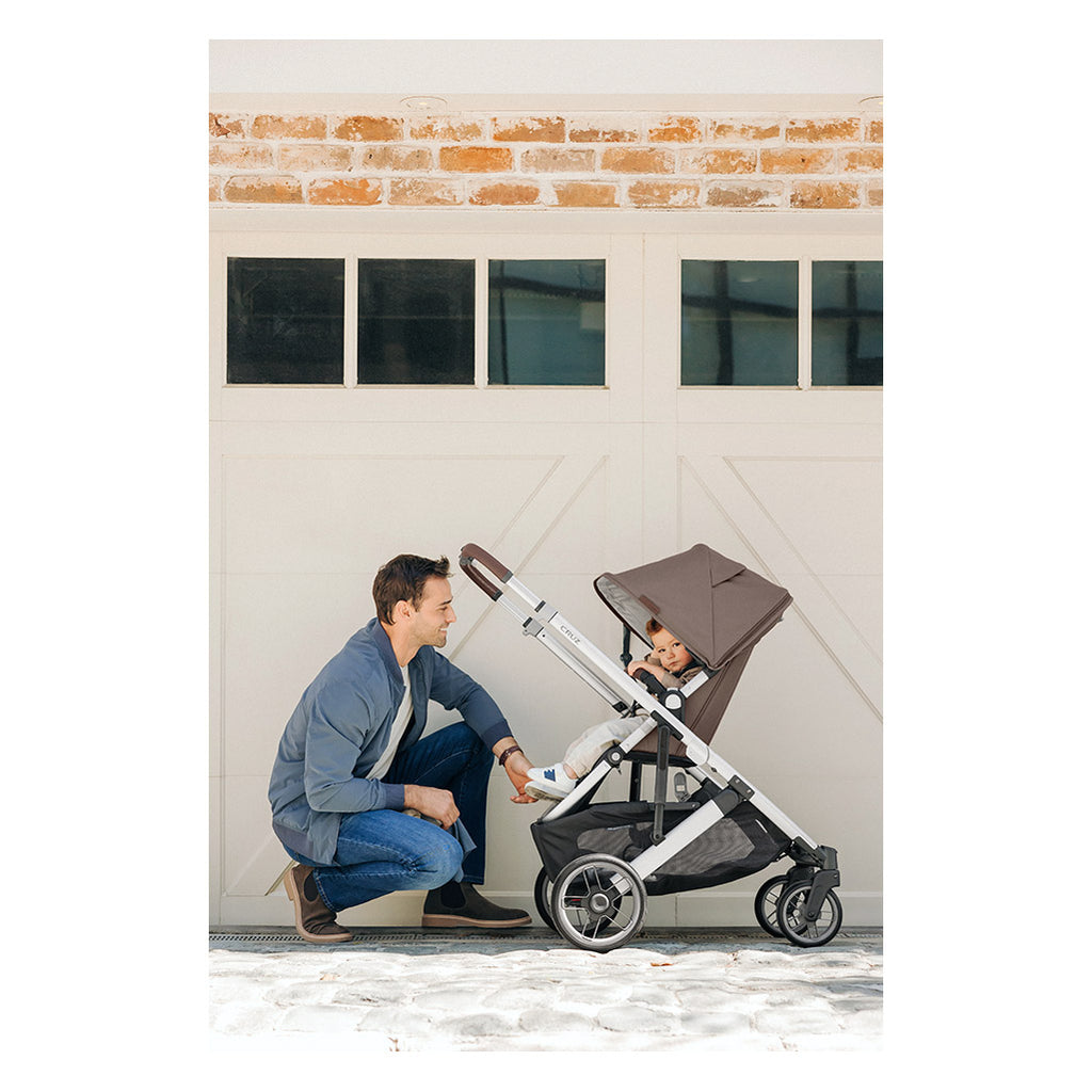 Man pushing child in Cruz stroller by Uppababy