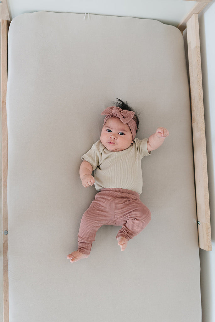 Baby wearing the dusty rose Mebie Baby organic cotton leggings 