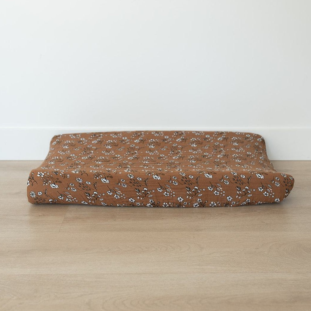 Soft florals meet function with the Mebie Baby Vintage Floral Muslin Changing Pad Cover, designed for a cozy baby changing pad.