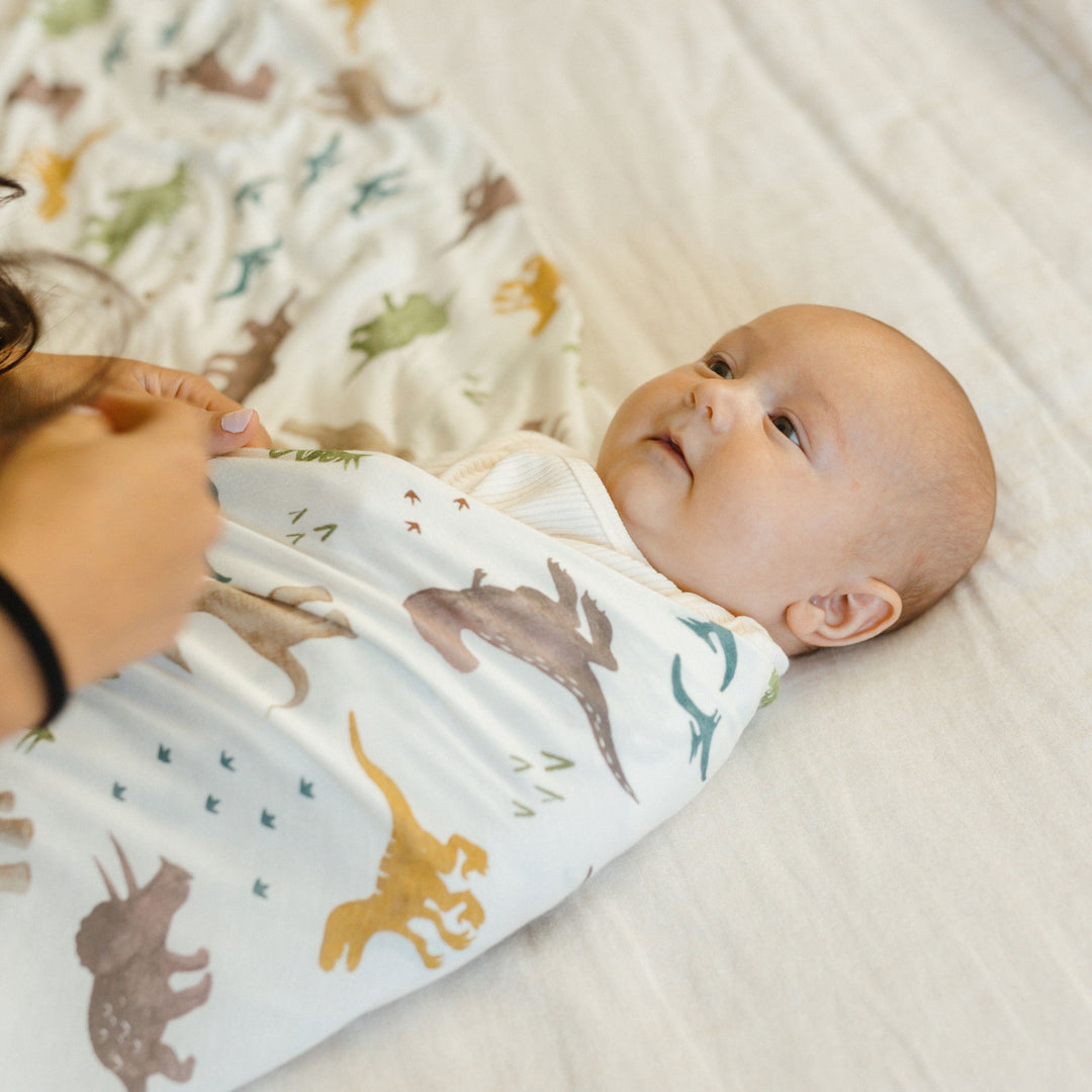 Swaddling muslin blanket in Dino Pals print by Little Unicorn, ideal for gentle baby wrapping
