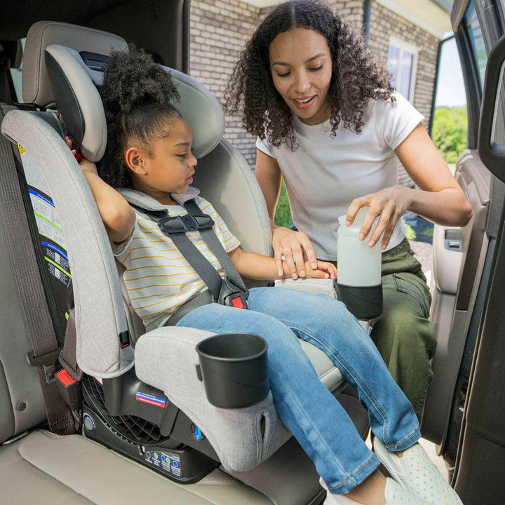 Mom buckling her child into the Britax One4Life Slim car seat in Parchment