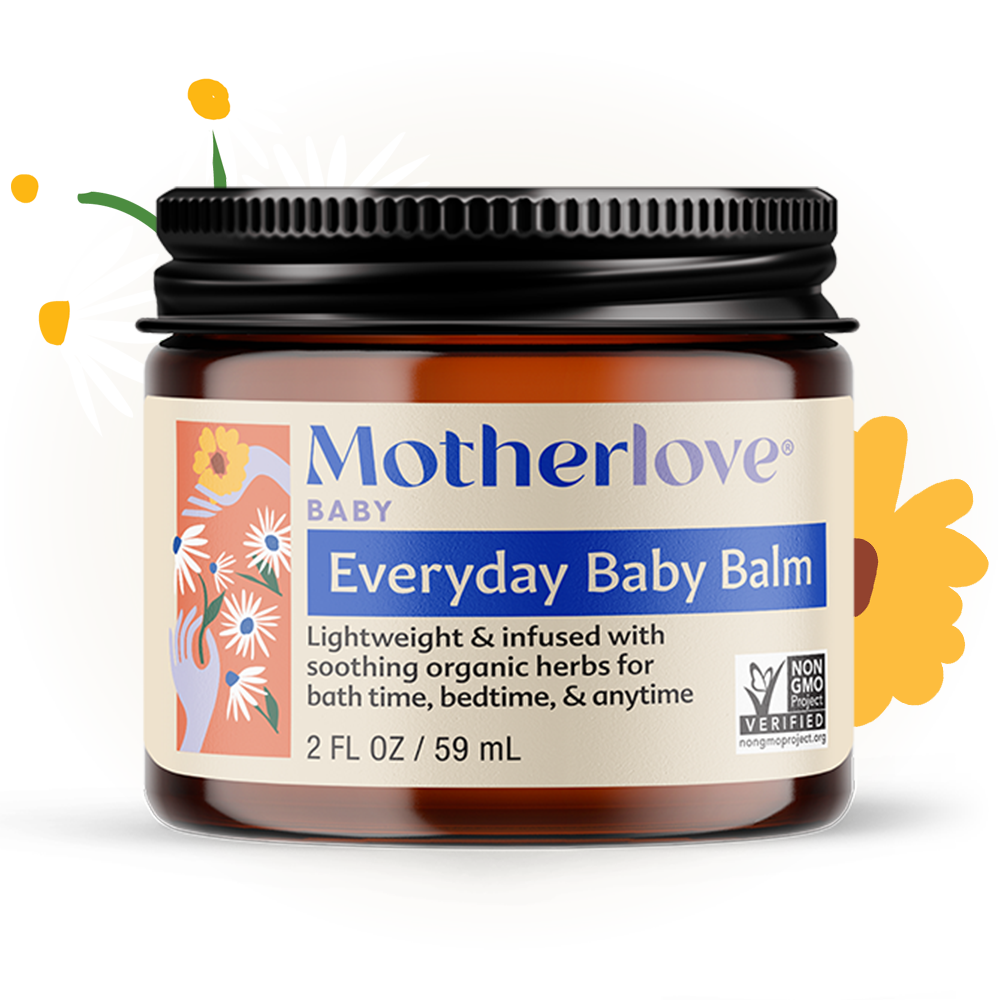 Motherlove Everyday Baby Balm pictured with fresh herbs, a soothing moisturizing skin balm for delicate baby skin.