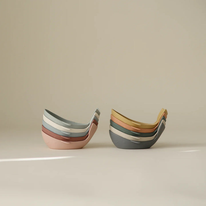 Mushie Whale Bath Stackers Original styled flat lay - silicone stacking cups with coordinating bath accessories