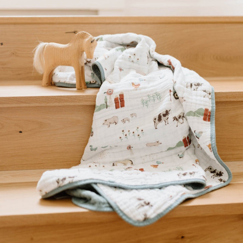 Soft Little Unicorn Original Cotton Muslin Quilt - Farmyard draped over stairs, ideal for nurseries and cozy baby quilts collections.