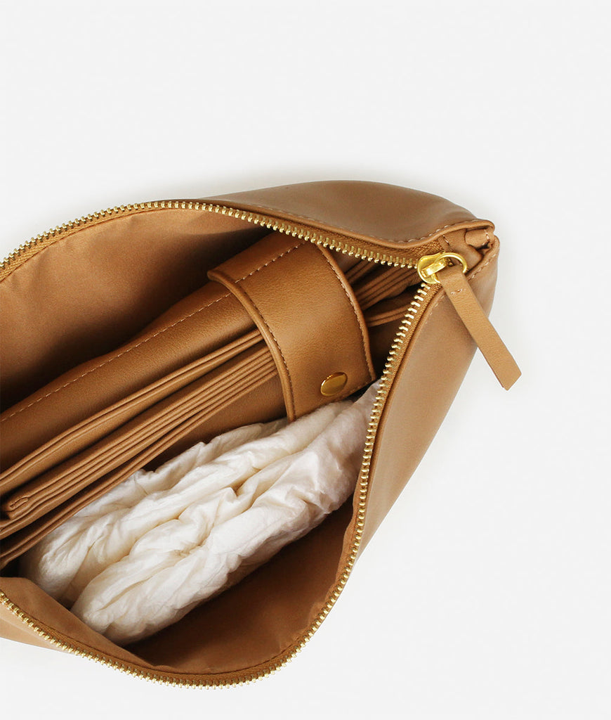 Inside of the Fawn Design Changing Clutch Bag in Tan, the faux leather diaper changing bag for all your needs. Comes with faux leather matching diaper changing mat