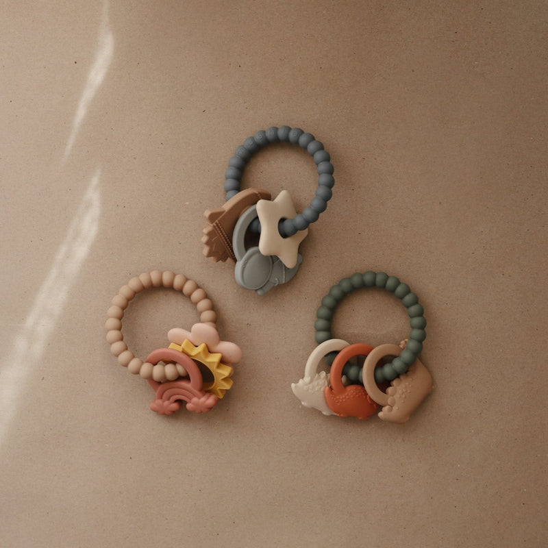 Flat lay of Mushie teething ring in space color