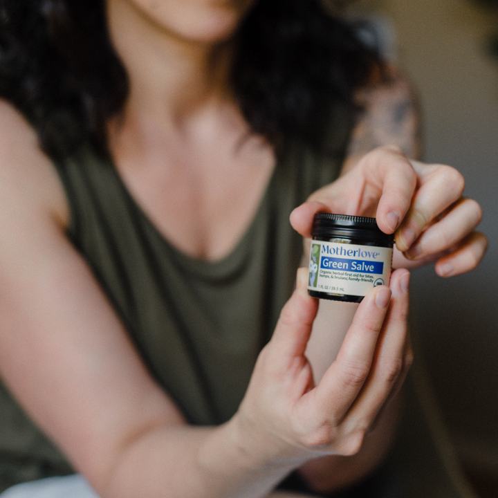 Flat lay of Motherlove Green Salve, highlighting its restorative blend of herbs used for soothing body balm care.