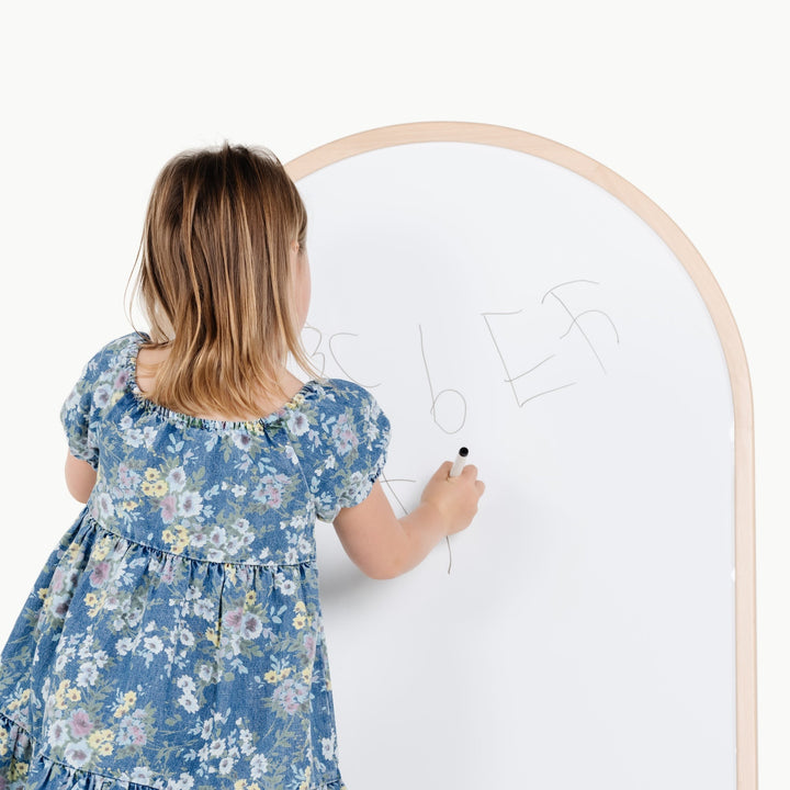 Girl sketches with a marker on the whiteboard side of this two sided Gathre chalkboard