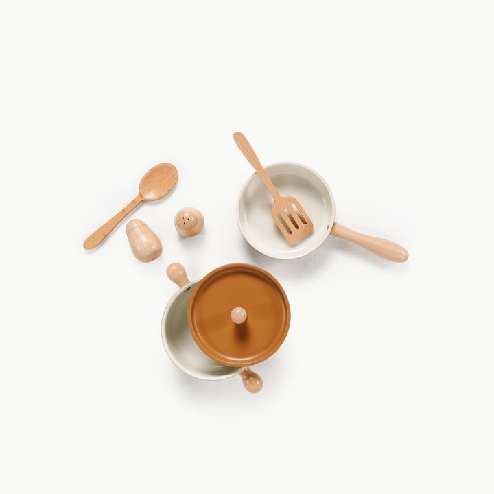 Play pan, spatula, fork, and salt and pepper shakers laid out from Gathre's cooking set
