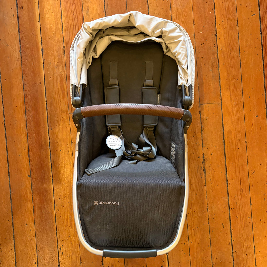 Open box UPPAbaby RumbleSeat V2+ in Bryce seen from above, new with tags, showing harness, canopy and bumper bar
