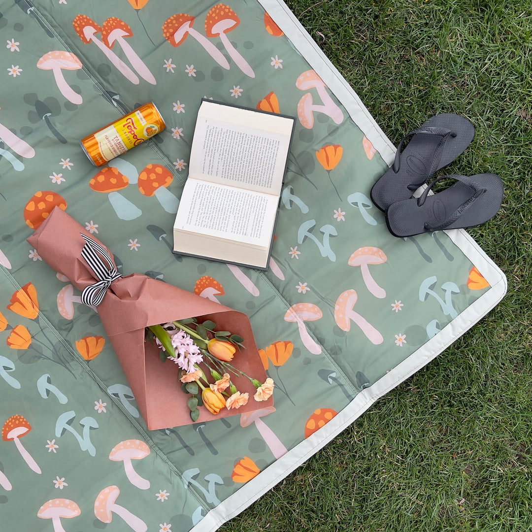 Set up on sand, Little Unicorn Outdoor Blanket - Woodland Mushroom makes a durable outdoor blanket waterproof.