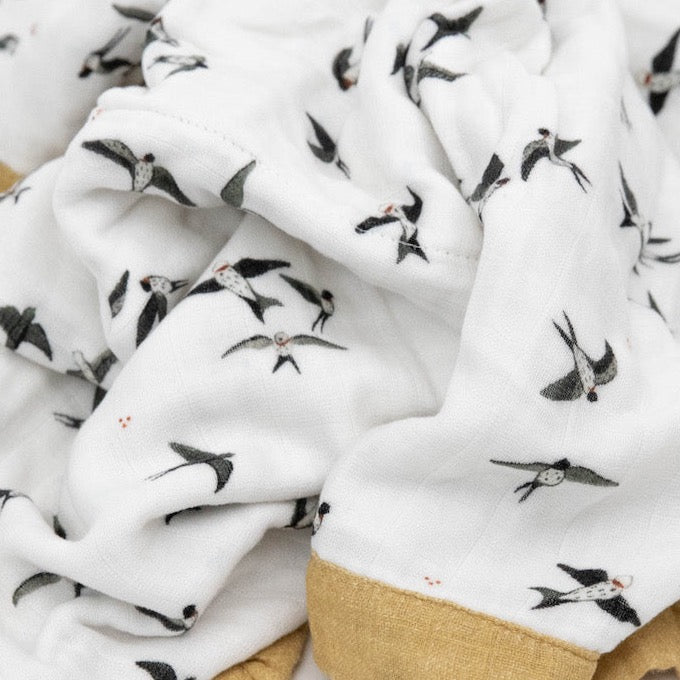 Close-up of Little Unicorn Organic Cotton Muslin Baby Quilt - Swallows, highlighting the detailed stitching of these premium muslin baby blankets.