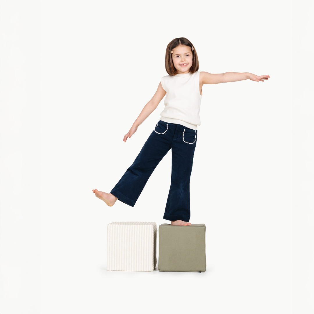 A child walks confidently across two stacked cubes from Gathre's toy line