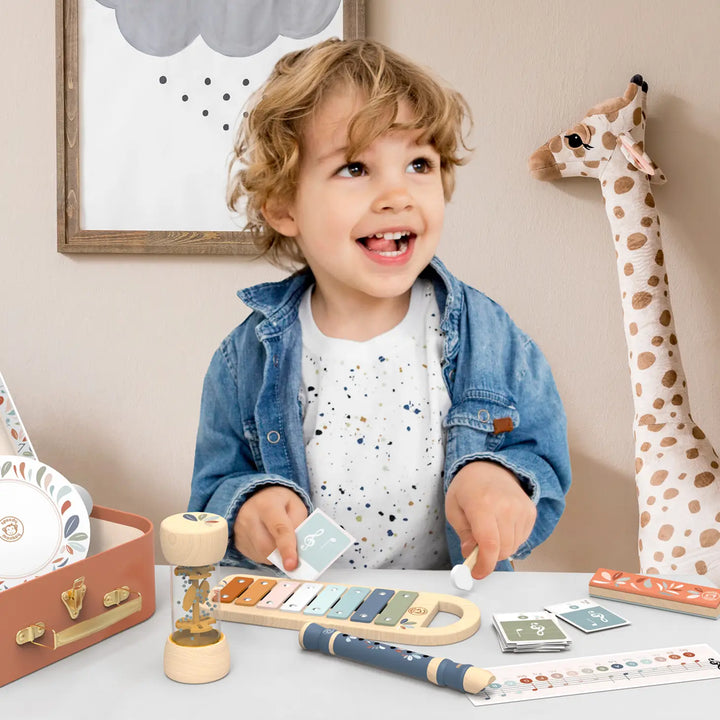 little boy playing with educational wooden musical toy instruments by Sppedy Monkey