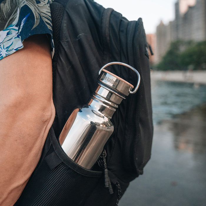 Outdoor lifestyle shot of Klean Kanteen 27oz Reflect with Bamboo Cap in Midnight Sky, highlighting leak proof and portable design