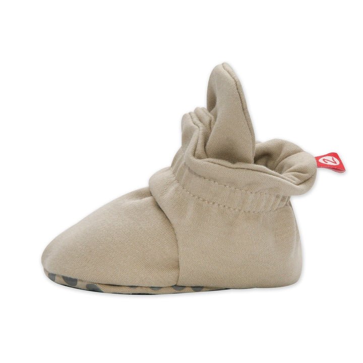 Side view of a single Zutano Organic Cotton Gripper Baby Bootie in Khaki with its red Z tab and snap cuff