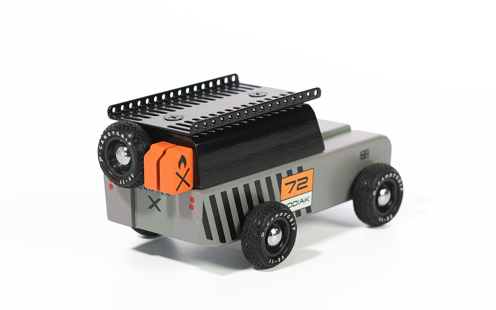 A rear-quarter angle highlights the Plantoys Drifter Kodiak, a sleek wooden design perfect for fans of toy cars.