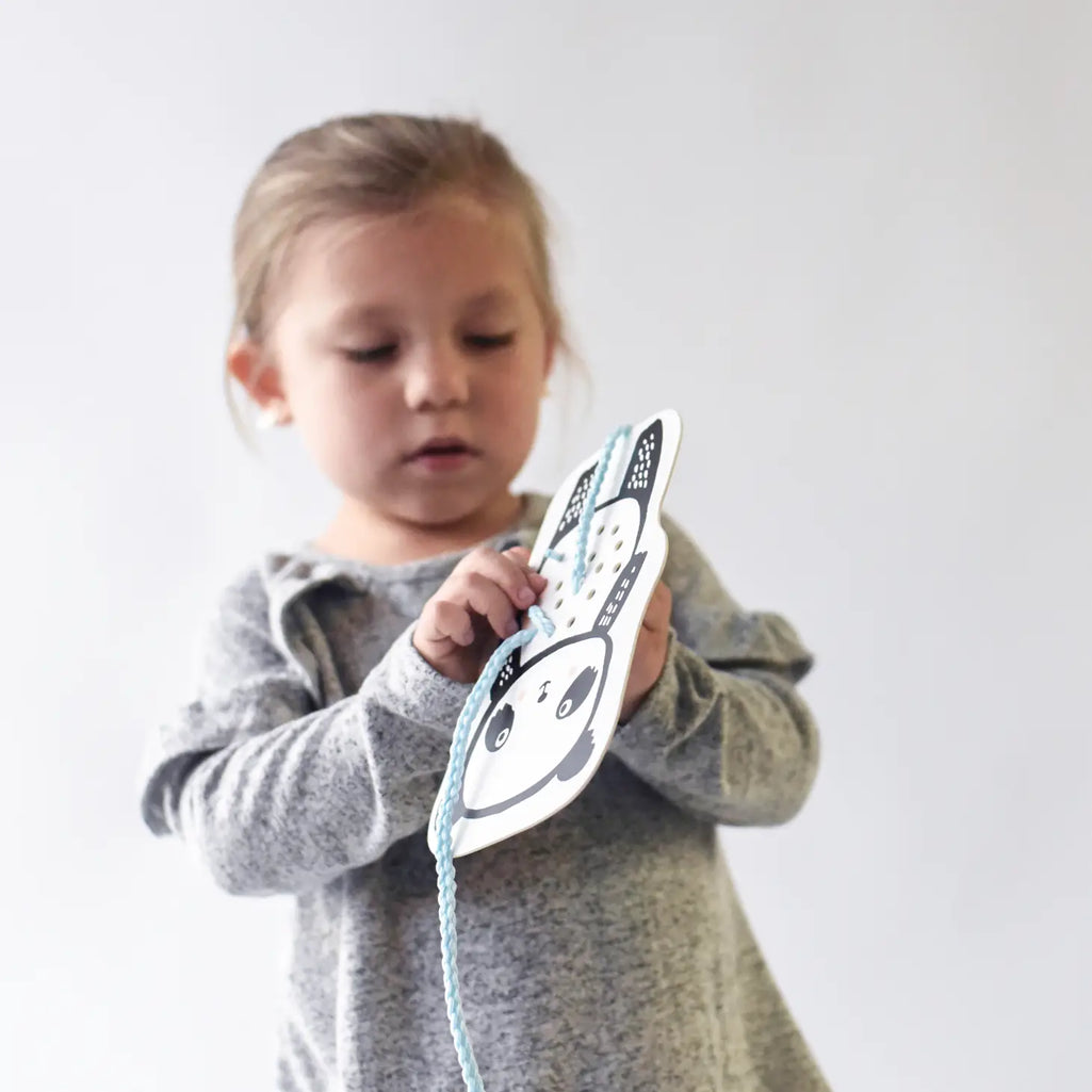 little girl playing with lacing art cards