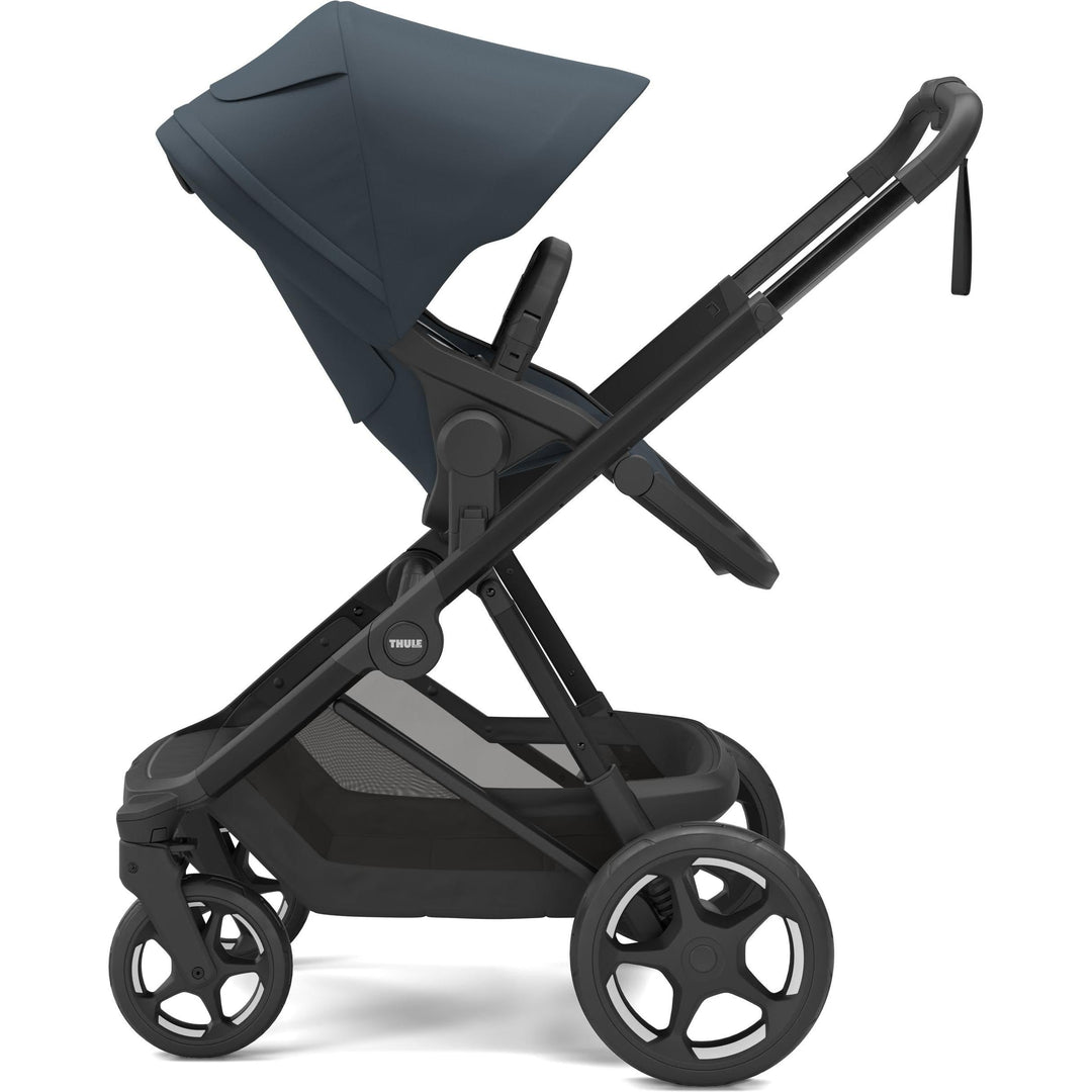 Darkest blue on black Thule Charm Stroller reversible seat stroller, parent-facing seat, side view