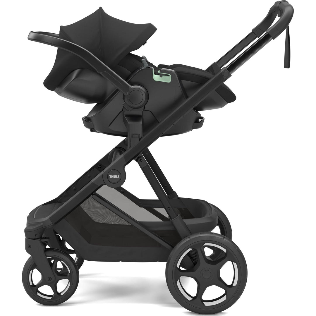 Black on black Thule Charm Stroller premium baby stroller, with Thule Maple car seat, side view