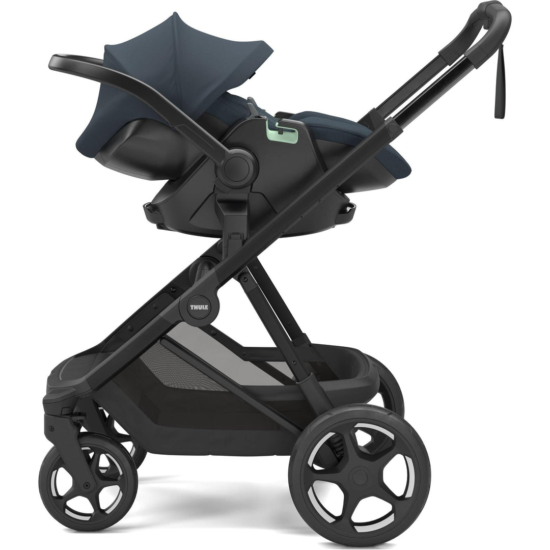 Darkest blue on black Thule Charm Stroller full-size stroller from birth, with Thule Maple car seat, side view