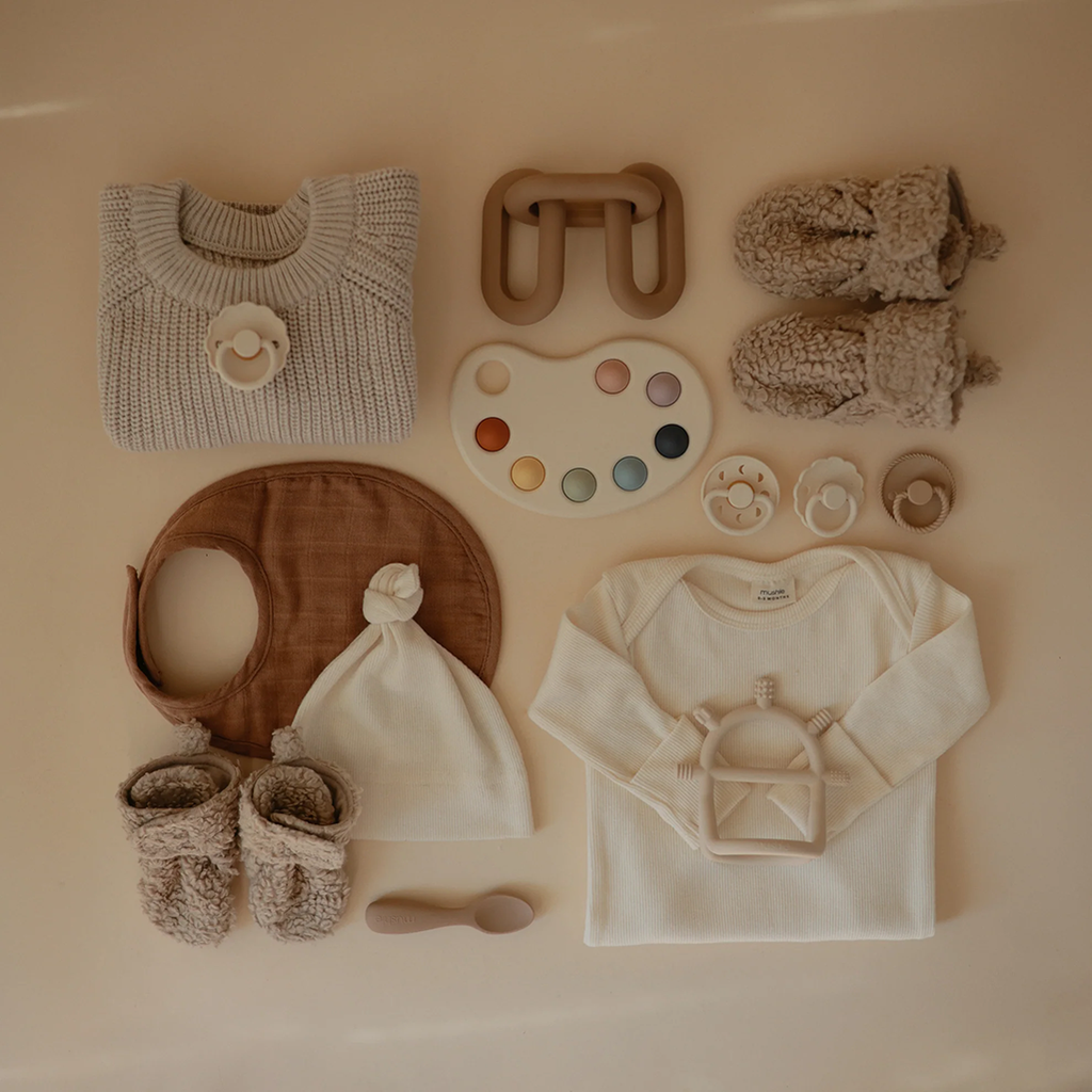 soft tan baby booties with other mushie products