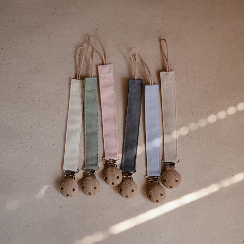 Charming  Collection of Mushie Linen Pacifier Clips offers durable baby pacifier clips for daily use.