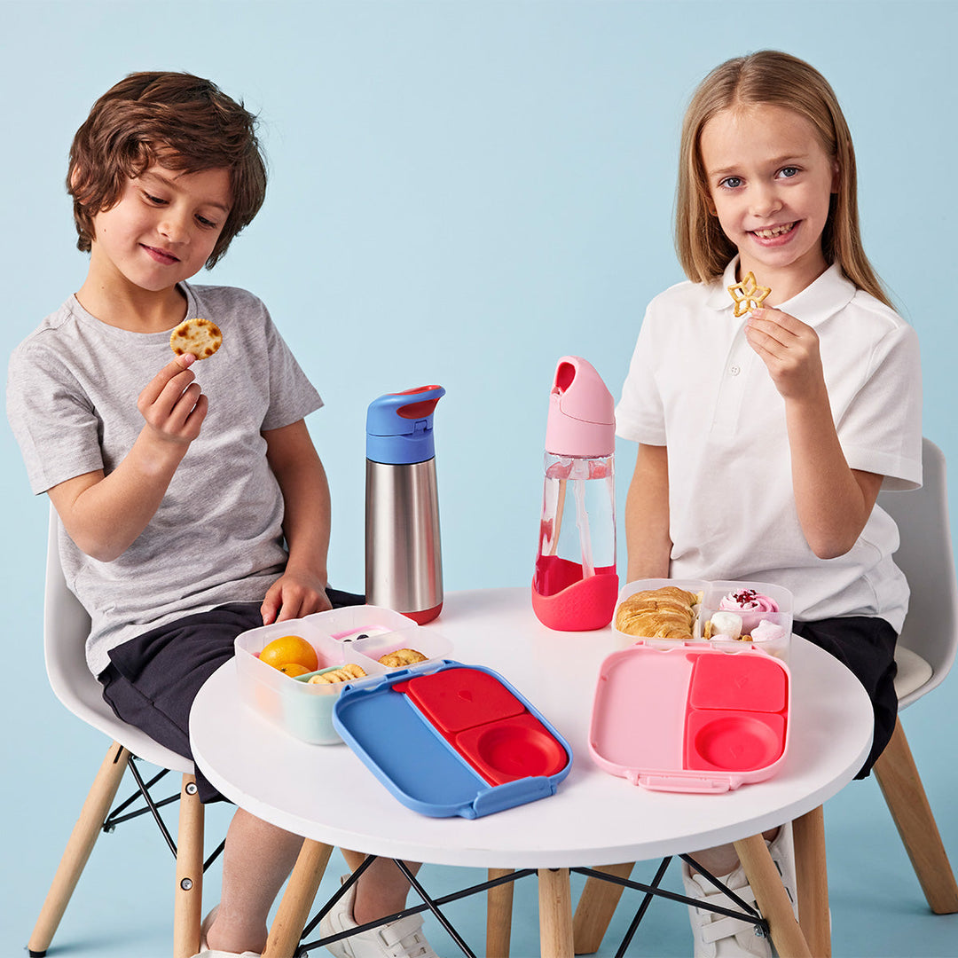 two children eating from b.box bento boxes and insulated bottle