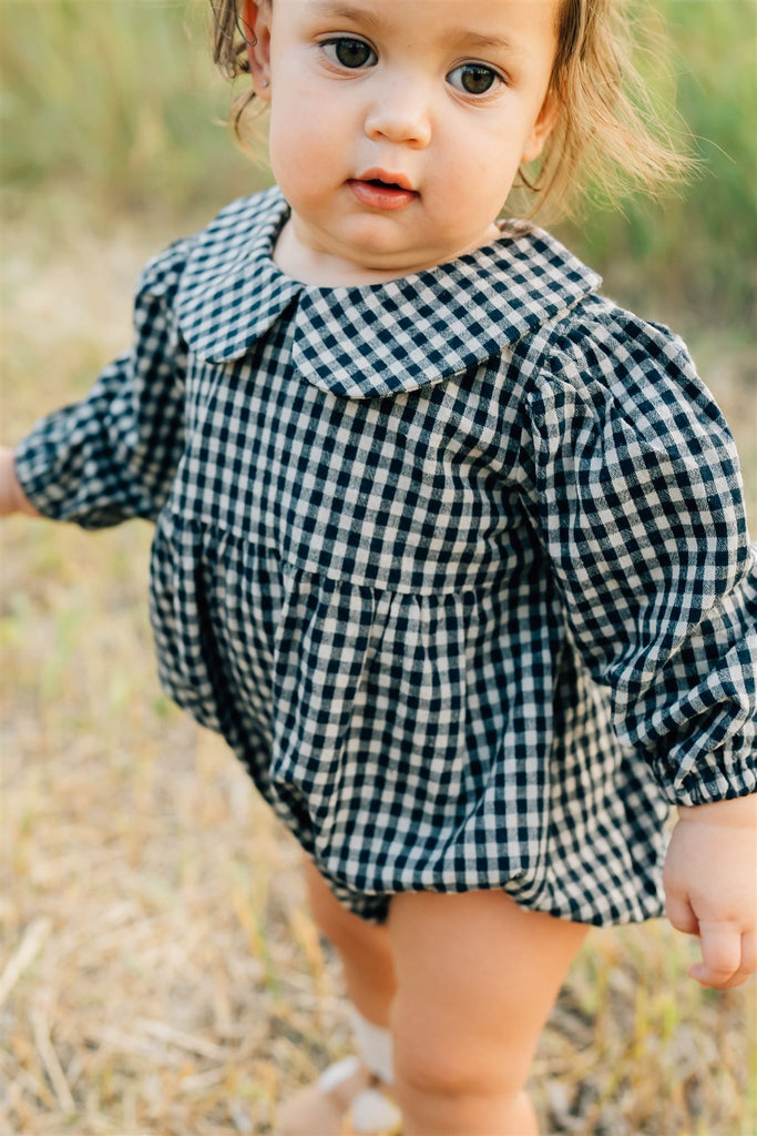 Baby wearing Mebie Baby's gingham long sleeve Romper