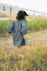 Girl walking in the Mebie Baby ruffle linen dress