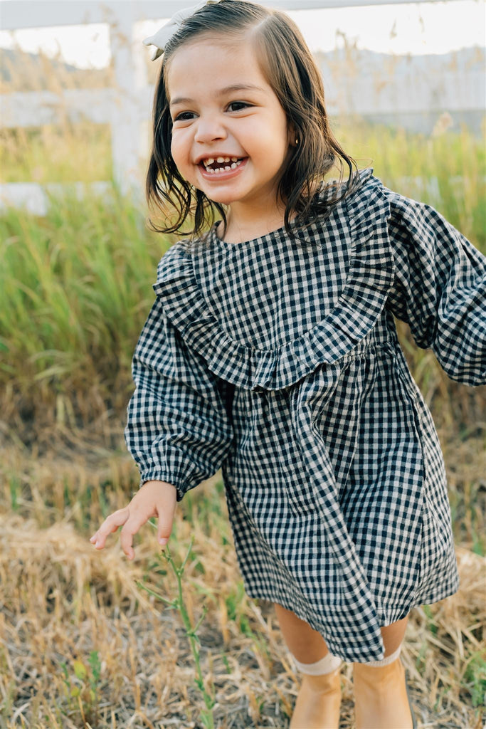 Young girl wearing the Mebie Baby linen ruffle dress.