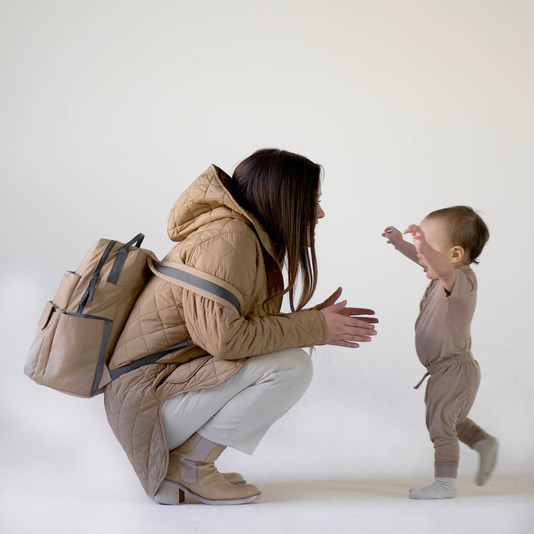 Child wearing Little Unicorn Red Rovr Roo Backpack - Toffee outdoors, the perfect kids travel backpack for any outing.