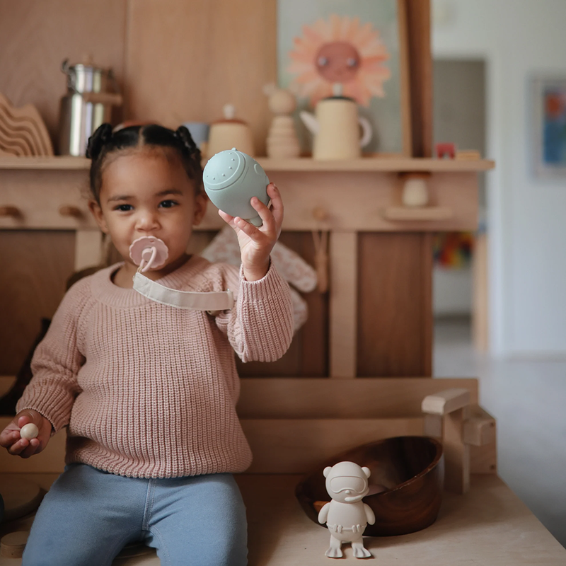 Toddler with Mushie Pacifier Clip blush pink
