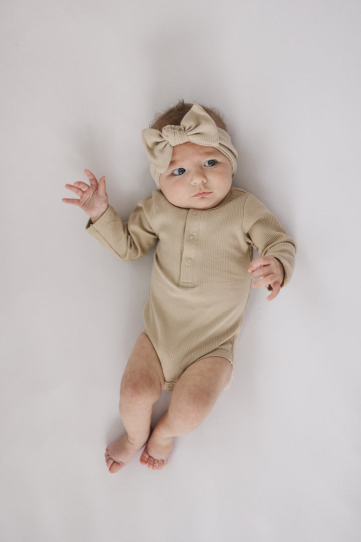 Oatmeal Organic Snap Long Sleeve Ribbed Bodysuit from Mebie Baby, shown up close to highlight the snap closures.