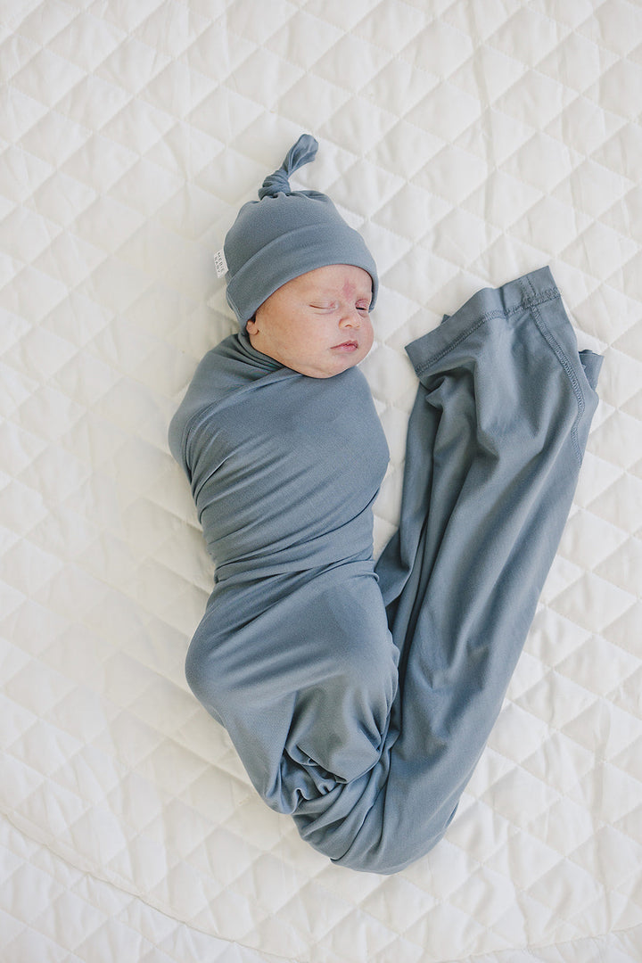 Shop swaddle blankets at Mebie Baby now, the Dusty Blue Bamboo Stretch Swaddle styled with matching nursery decor.