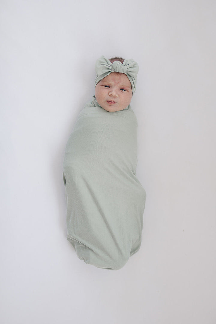 Sage Bamboo Stretch Swaddle from Mebie Baby, shown in a flat lay to highlight the fabric.