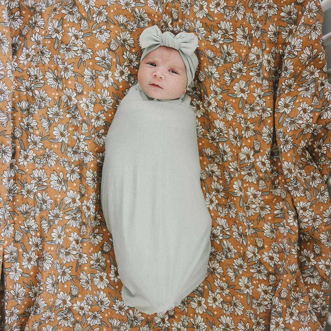 Shop swaddle blankets at Mebie Baby now, the Sage Bamboo Stretch Swaddle styled with matching nursery decor.